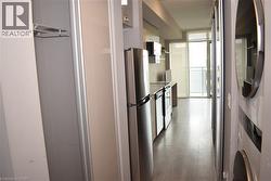 Compact kitchen featuring stainless steel appliances including a refrigerator, dishwasher, and stove - 