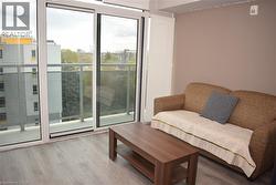 Sliding glass doors opening to a private balcony with glass panel railing - 