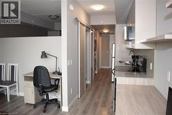 Compact kitchen area featuring a built-in microwave, a flat-top electric range, and light granite-look countertops - 