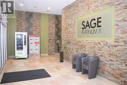 Lobby area featuring stone-finish wall accents, light-toned floor tiling, and a building directory sign - 