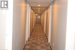 Hallway with recessed lighting, neutral wall finishes, and patterned carpet - 