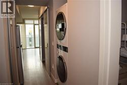 In-unit laundry appliances, wood-finish flooring, and a stainless steel refrigerator - 