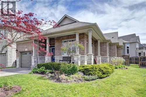 Brick and stone exterior featuring a covered front porch with substantial columns - 219 Falconridge Drive, Kitchener, ON - Outdoor