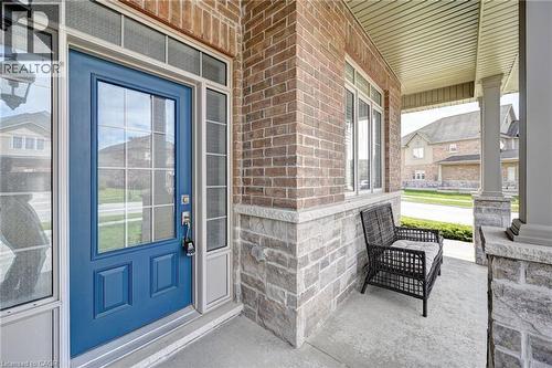 Inviting front entry featuring a bold blue door with glass lites, sidelights, and a transom window - 219 Falconridge Drive, Kitchener, ON - Outdoor With Exterior