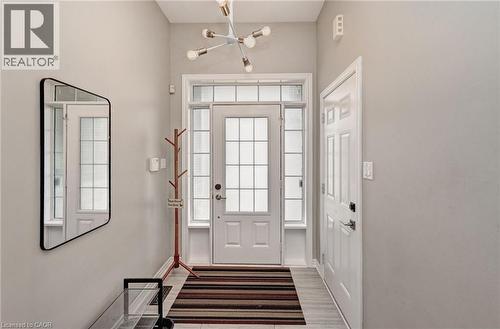Entryway featuring a transom window and sidelights, a modern multi-bulb chandelier, and wood-finish flooring - 219 Falconridge Drive, Kitchener, ON - Indoor Photo Showing Other Room