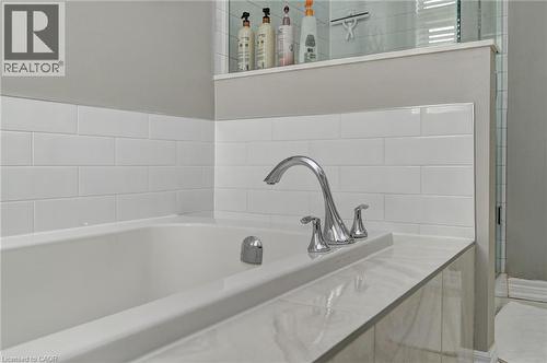Soaking tub with subway tile surround, chrome fixtures, and a tiled deck - 219 Falconridge Drive, Kitchener, ON - Indoor Photo Showing Bathroom
