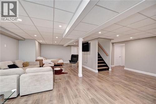 Spacious lower-level area with wood-finish flooring, recessed lighting, and light grey wall finishes - 219 Falconridge Drive, Kitchener, ON - Indoor