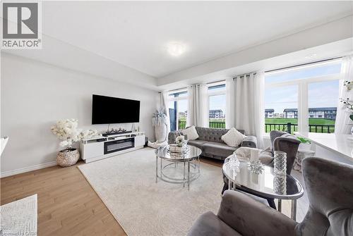 Bright living space featuring wood-finish flooring, recessed lighting, and large windows - 176 Wheat Lane, Kitchener, ON - Indoor Photo Showing Living Room