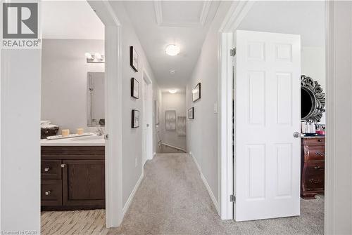 Carpeted hallway featuring a recessed ceiling light fixture, white paneled doors, and light gray walls - 176 Wheat Lane, Kitchener, ON - Indoor Photo Showing Other Room