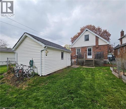 Expansive green lawn with a detached garage featuring white siding and a dark shingled roof - 75 Barons Avenue S, Hamilton, ON - Outdoor With Deck Patio Veranda With Exterior