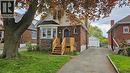 Brick and siding residence featuring a bay window with stone accents, a new wood deck, and a paved driveway leading to a detached garage - 75 Barons Avenue S, Hamilton, ON  - Outdoor 