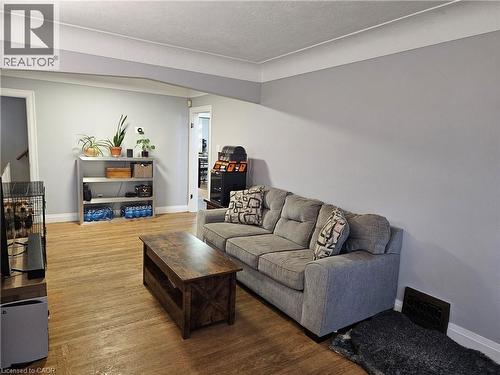 Living area featuring wood-finish flooring, light gray walls, and white crown molding - 75 Barons Avenue S, Hamilton, ON - Indoor Photo Showing Living Room