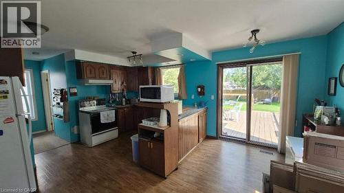 Kitchen featuring wood-finish flooring, wood cabinetry, and patio doors leading to outside deck. - 257 Cedar Street, Simcoe, ON - Indoor Photo Showing Kitchen