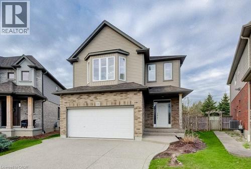 Two-story residence featuring a brick and siding exterior, an attached single-car garage, an exposed aggregate driveway, and a front entrance with a covered porch - 331 Westpark Crescent Unit# Upper, Waterloo, ON - Outdoor With Facade