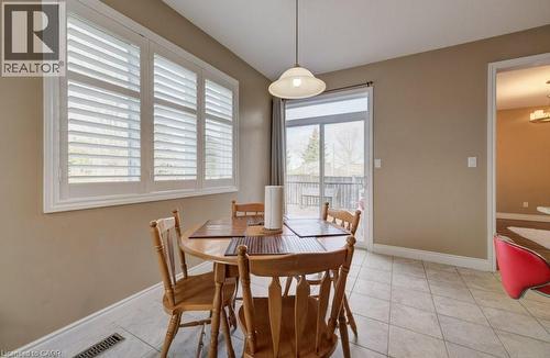 Dining area featuring large windows with white plantation shutters, a sliding glass door to an exterior deck, and tiled flooring - 331 Westpark Crescent Unit# Upper, Waterloo, ON - Indoor Photo Showing Dining Room