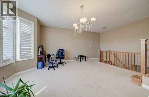 Spacious upper-level area featuring neutral wall tones, light-colored carpeting, and a decorative chandelier - 331 Westpark Crescent Unit# Upper, Waterloo, ON - Indoor