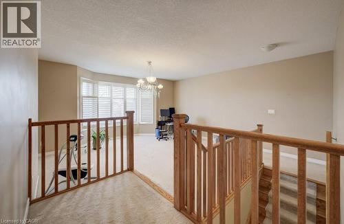 Carpeted landing featuring wood railings and a chandelier - 331 Westpark Crescent Unit# Upper, Waterloo, ON - Indoor Photo Showing Other Room