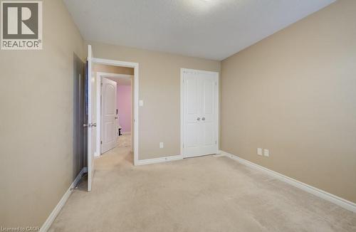 Carpeted room featuring neutral wall paint, white trim, and a built-in closet with white double doors - 331 Westpark Crescent Unit# Upper, Waterloo, ON - Indoor Photo Showing Other Room