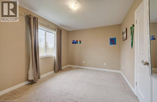 Carpeted room featuring a large window with neutral drapery, light tan walls, and white trim - 331 Westpark Crescent Unit# Upper, Waterloo, ON - Indoor Photo Showing Other Room