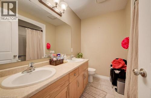 Bathroom featuring a dual vanity with light-toned laminate countertops, two undermount sinks, and natural wood-finish cabinetry - 331 Westpark Crescent Unit# Upper, Waterloo, ON - Indoor Photo Showing Bathroom