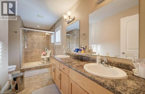 Bathroom featuring a dual-sink vanity with light wood cabinetry, a patterned countertop, and expansive mirrors - 331 Westpark Crescent Unit# Upper, Waterloo, ON - Indoor Photo Showing Bathroom