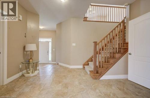 Entry foyer featuring neutral-toned tile flooring, a wood staircase with carpeted treads, and a white paneled entry door with sidelights - 331 Westpark Crescent Unit# Upper, Waterloo, ON - Indoor Photo Showing Other Room