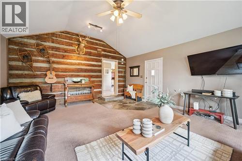 Vaulted ceiling with a ceiling fan, a log-style accent wall, and a stone flooring transition - 630 Robert Ferrie Drive, Kitchener, ON - Indoor