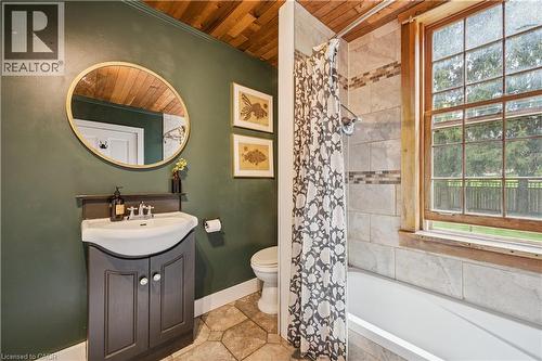 Bathroom featuring a wood-finish plank ceiling, a pedestal sink vanity with cabinet storage, a tiled shower-over-tub combination, a wood-frame window, and hexagonal floor tiling - 630 Robert Ferrie Drive, Kitchener, ON - Indoor Photo Showing Bathroom