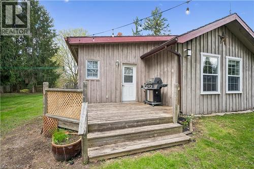Exterior featuring vertical plank siding, a wood deck with steps, and multiple windows - 630 Robert Ferrie Drive, Kitchener, ON - Outdoor