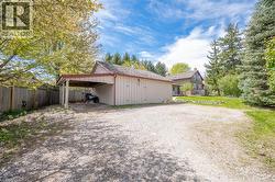 Detached garage with attached carport and gravel driveway - 