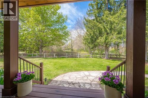 Expansive green lawn framed by mature trees, featuring a natural stone pathway - 630 Robert Ferrie Drive, Kitchener, ON - Outdoor
