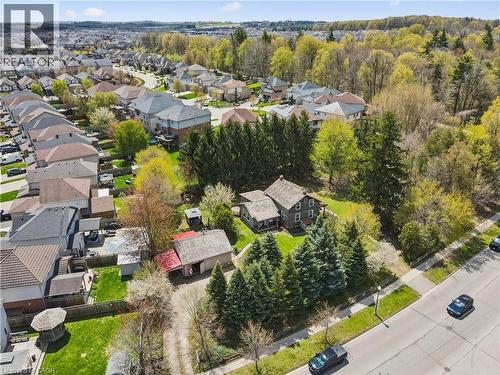 Detached residence with a traditional exterior, featuring a stone pathway, mature trees, a detached garage, and an adjacent street - 630 Robert Ferrie Drive, Kitchener, ON - Outdoor With View