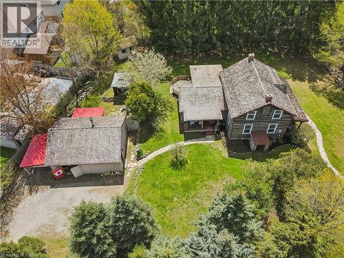 Expansive property featuring a multi-level log cabin, a detached outbuilding with a red-roofed lean-to, and a gravel driveway - 630 Robert Ferrie Drive, Kitchener, ON - Outdoor