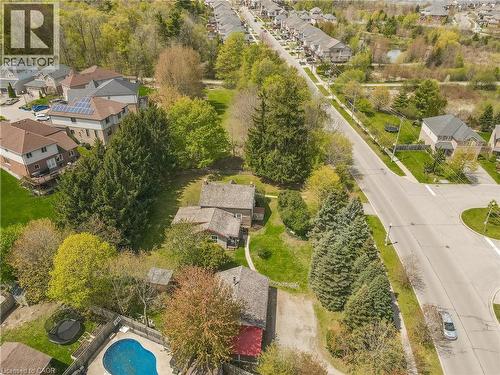 Aerial view showcasing the property's irregular-shaped swimming pool, surrounded by mature trees and a fenced perimeter - 630 Robert Ferrie Drive, Kitchener, ON - Outdoor With View