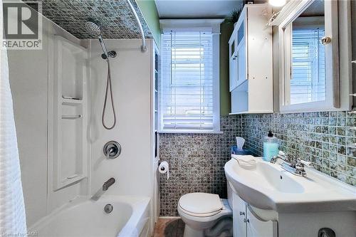 Upper Bathroom featuring healthy amount of natural light, vanity, tile walls, and washtub / shower combination - 156 Park Row S, Hamilton, ON - Indoor Photo Showing Bathroom