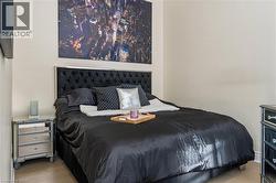 Bedroom featuring light-toned wall paint and wood-finish flooring - 