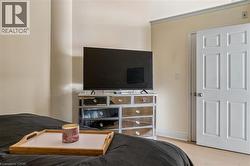 Bedroom featuring neutral wall paint, white trim, and a six-panel door with a round knob - 