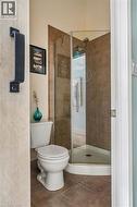 Full bathroom featuring a corner shower with glass enclosure, brown tile surround, and an integrated showerhead - 