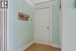 Light blue painted wall with white trim, wood-finish flooring, and white interior doors - 