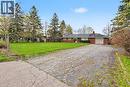 Brick ranch home featuring a single garage, dark shingle roof, and a prominent chimney - 355 Guelph Avenue, Cambridge, ON 