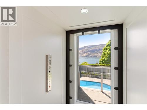 Glass elevator that connects all 3 levels of the home - 2090 Bennett Road, Kelowna, BC -  Photo Showing Other Room With In Ground Pool