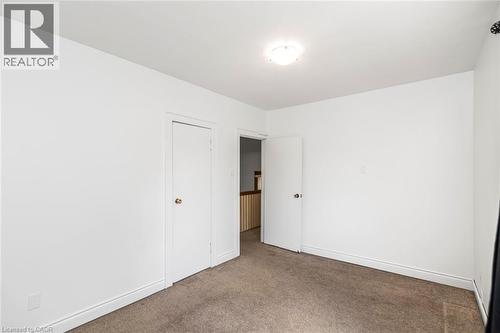 Neutral wall finishes with a ceiling-mounted light fixture, offering ample space and two white doors - 114 Weir Street N, Hamilton, ON - Indoor Photo Showing Other Room
