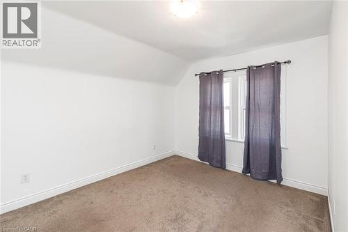 Carpeted room with a window, white walls, and a ceiling-mounted light fixture - 114 Weir Street N, Hamilton, ON - Indoor Photo Showing Other Room