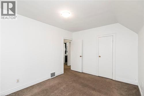 Carpeted room with white walls, white trim, and a semi-flush mount ceiling light - 114 Weir Street N, Hamilton, ON - Indoor Photo Showing Other Room