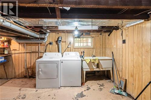Laundry area featuring wood-paneled walls and a utility sink - 114 Weir Street N, Hamilton, ON - Indoor Photo Showing Laundry Room