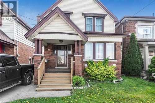 Brick and siding exterior with a covered front porch featuring square columns - 114 Weir Street N, Hamilton, ON - Outdoor