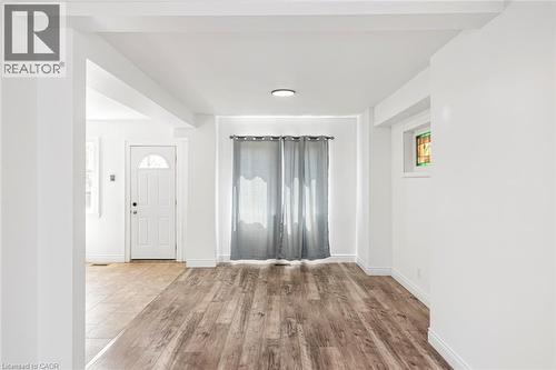Interior space featuring wood-finish flooring, white walls, and a recessed ceiling light - 114 Weir Street N, Hamilton, ON - Indoor Photo Showing Other Room
