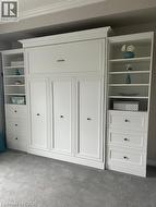 Integrated wall unit featuring a pull-down bed system, flanking open shelving, and built-in drawer storage - 