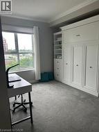 Built-in wall unit with storage and display shelving, accompanied by a large window and grey carpeting - 