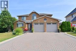 Brick exterior with a prominent arched window and a two-car garage - 